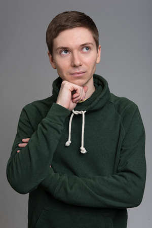 Young Man Thinking isolated on a gray backgroundの写真素材
