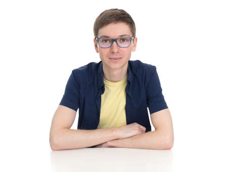 guy sitting and thinking on a table isolated on white backgroundの写真素材