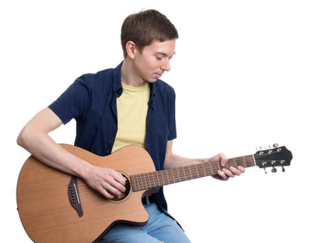 Handsome young man musician playing his guitar. Isolated over white background.