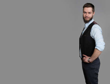 portrait of handsome young businessman smiling wearing casual suit isolated on greyの写真素材