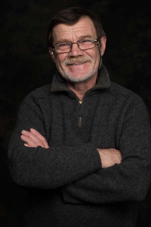 Closeup portrait of elderly man with beard on a black backgroundの写真素材