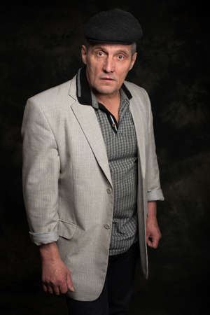 portrait of handsome serious senior man over dark backgroundの写真素材