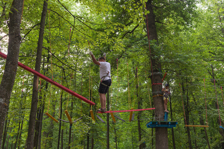 July 30, 2016. Photo of father and daughter climbing on trees in the amusement park. Cheboksary. Russia.のeditorial素材