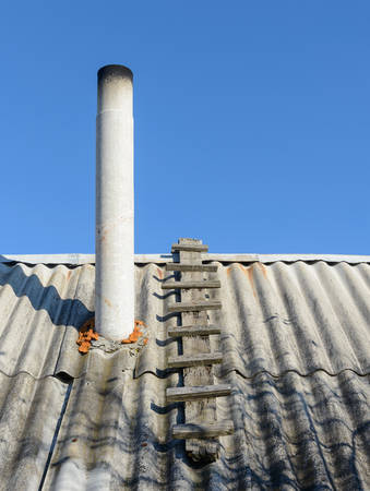old roof slate from the chimney on a background of blue skyの写真素材