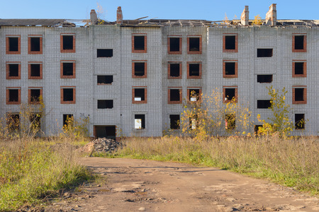 dilapidated abandoned brick apartment house among the fieldsの写真素材