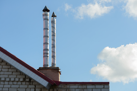 old chimneys against the blue sky with cloudsの写真素材