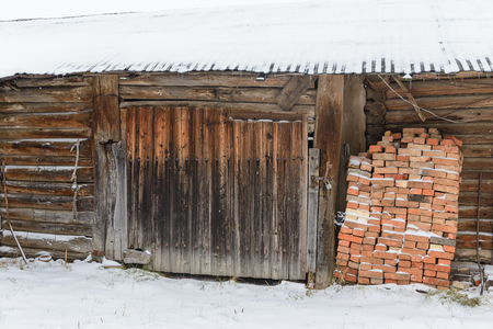 old abandoned barn with the snow-covered roofの写真素材