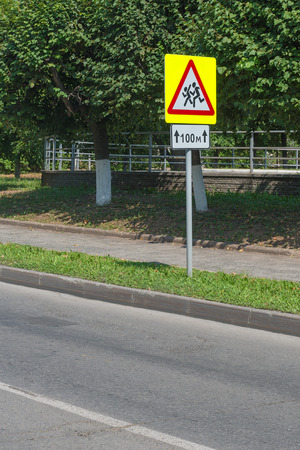 road sign "warning children" length of one hundred meters of standing at the asphalt roadの写真素材