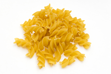 handful of pasta spirals on a white backgroundの写真素材