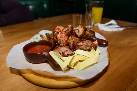 pieces of meat, garnish and sauce on a wooden standの写真素材