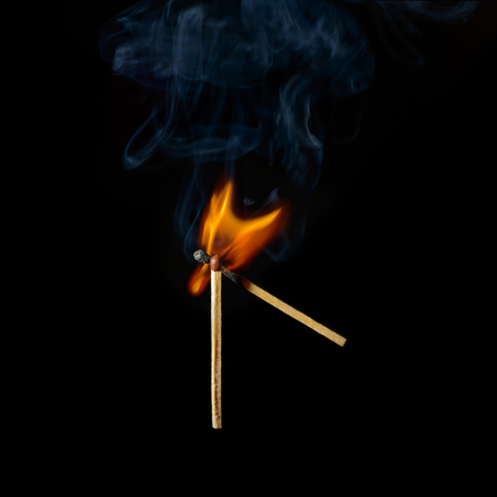 one match ignites another on a black backgroundの写真素材