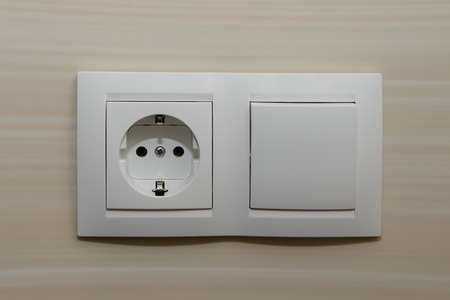Double socket with a switch on the wall of tiles