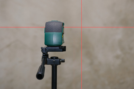 perpendicular to the rays of the laser level on the plastered wall