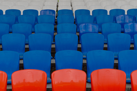 empty seats for spectators at the stadium painted in white blue and red colors of the national flag of Russiaの写真素材
