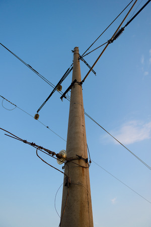 high round concrete pillar with wires on blue sky backgroundの写真素材