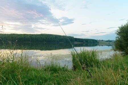 Evening summer landscape with a fishing rod on the lakeのeditorial素材
