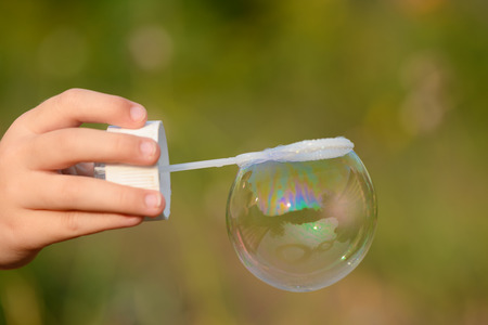 Soap bubble in the frame on children's handsの写真素材
