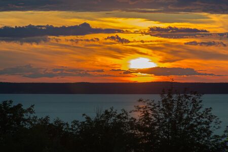 Landscape with a sunset over a wide riverの写真素材