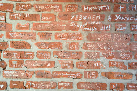 Numerous inscriptions on the red bricks of the old wallの写真素材
