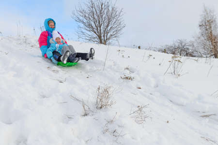 January 2, 2019: a Woman and a girl go sledding down a snow slide. Russia. Chuvashia.のeditorial素材