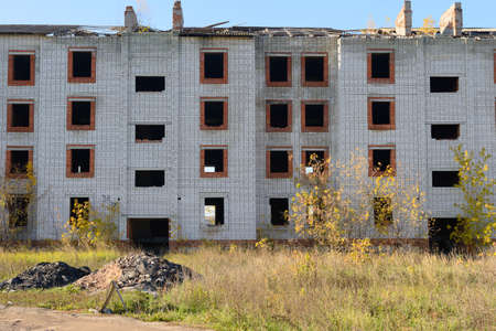 Old apartment building collapsing unfinished on a summer day