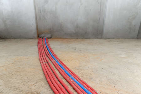 Heating red and blue pipes on the floor of a new building