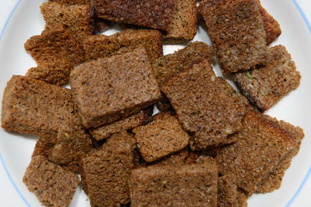 Rye bread crackers on a white plate. Top view.