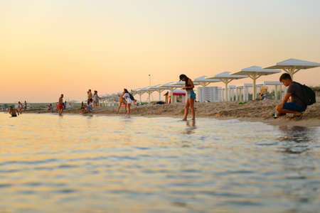 July 9, 2021: People on the beach relax and take pictures of the sunset. Crimea.のeditorial素材