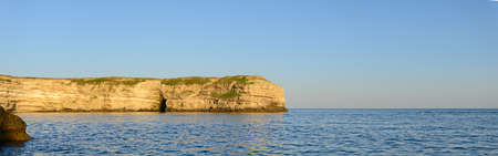Seashore with steep cliffs on a summer eveningの写真素材
