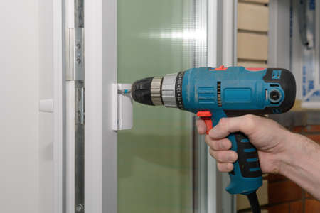 Fixing the handle to the plastic door with a screwdriverの写真素材
