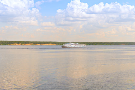 A cruise river ship sails along the Volga River on a sunny summer dayの写真素材