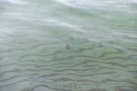 Sandy bottom of the sea through clear clear waterの写真素材