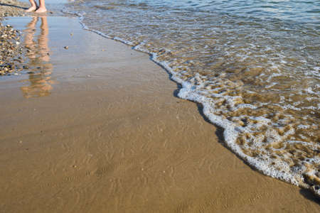 Sandy beach with an incoming wave on a summer dayの写真素材