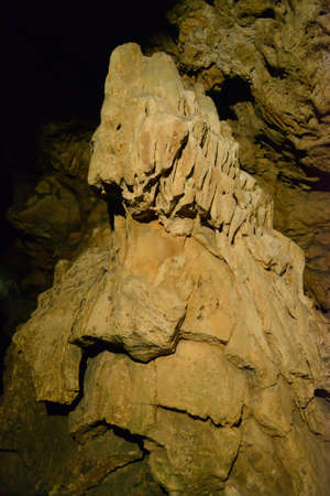 An irregular stalagmite in a dark caveの写真素材