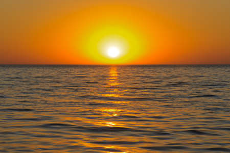 Sunset over the calm waters of the seaの写真素材