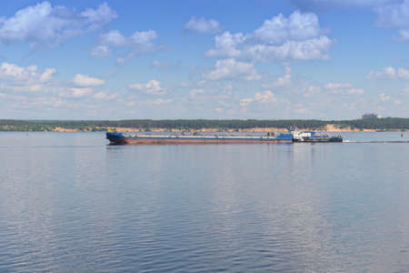 A cargo river barge sails along the Volga River on a sunny summer dayのeditorial素材
