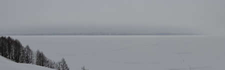 Buildings in the city on the opposite bank of the river on a cloudy winter dayの写真素材