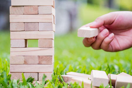 Closeup of asian women's hand playing wood blocks stack game