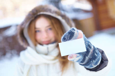 Young beautiful woman with blank visiting card  Winter の写真素材