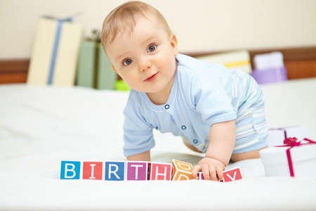 Portrait of baby boy on bed. Birthday concept.