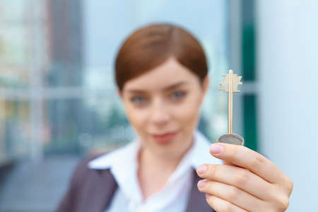 Businesswoman holds door key.の写真素材