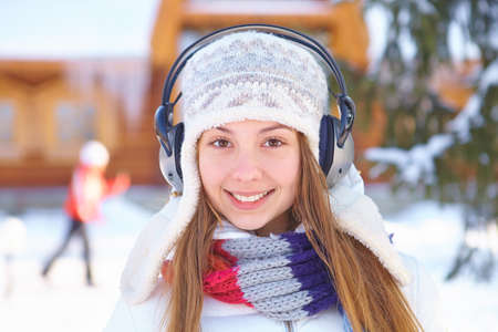 Outdoors on a winter day. Girl listen music.の写真素材