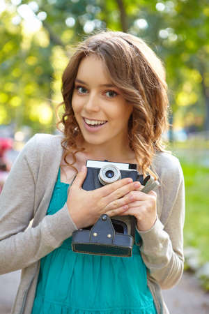 Young woman uses film photocamera.