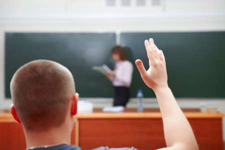 Back to school. Student with arm raised.