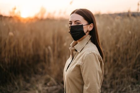 Woman in a protective mask while walking. Sunsets sunsetの写真素材