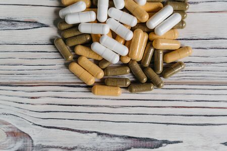 sprinkled pills and dietary supplements on a wooden background, vitamins and omega3 for immunityの写真素材