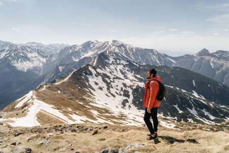 young hister guy with a beard in the mountains with a backpack. Active rest in one with natureの写真素材