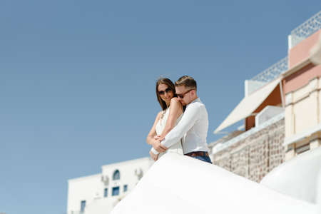 Happy couple hugging and laughing together with a view of Santorini. High quality photoの写真素材