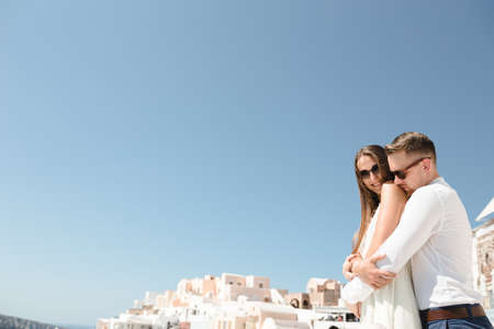 Happy couple hugging and laughing together with a view of Santorini. High quality photoの写真素材