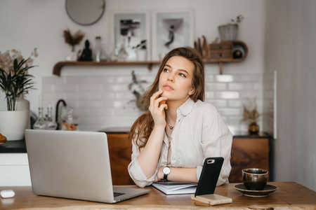 Emotional young woman using her laptop at home. High quality photoの写真素材